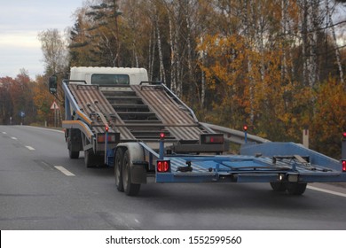 Delivery Auto Logistics, Empty Two-level Car Carrier Truck For Vehicle Transportation With Automobile Transporter Trailer On Country Road On Autumn Day, Rear Side View