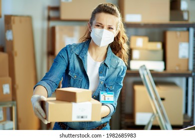 Delivery Business. Modern Female In Jeans With Ffp2 Mask Giving Parcel In The Office.