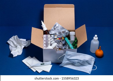 Delivery Cardboard Box With Medical Supplies On Dark Blue Background. Pills In Blister Packs. Cold And Flu Season