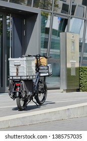 Delivery Cargo Ebike With A Box And Parcel In Front Of An Office Building  