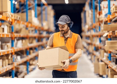 A delivery center worker is holding box with shipment and preparing it for delivery. - Powered by Shutterstock