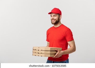 Delivery Concept: Young caucasian Handsome Pizza delivery man holding pizza boxes isolated over grey background - Shutterstock ID 1075013585