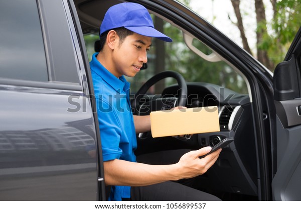 Delivery driver driving car with packages on\
seat outside the\
warehouse\
