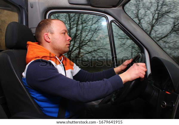 Delivery driver\
driving a cargo bus on the\
way