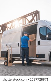 Delivery driver loading boxes into van for shipment. Delivery driver concept in a van. Man in blue uniform loading boxes into a delivery vehicle, representing logistics and shipping.