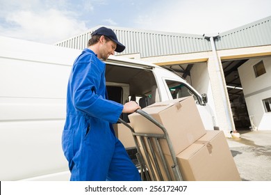 Delivery Driver Packing His Van In A Large Warehouse