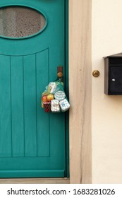 delivery during the quarantine. Shopping bag with Merchandise, goods and food is hanging at the front door, neighborhood Assistance concept at quarantine time because of coronavirus infection Covid-19 - Shutterstock ID 1683281026