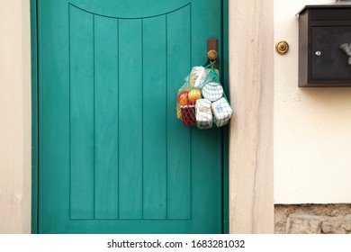 delivery during the quarantine. Shopping bag with Merchandise, goods and food is hanging at the front door, neighborhood Assistance concept at quarantine time because of coronavirus infection Covid-19 - Shutterstock ID 1683281032
