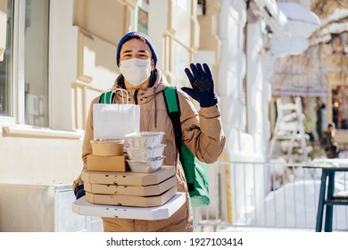 Delivery Employee Man In Facial Medical Maskat Thermal Takeaway Food Bag Backpack Pizza Boxes Work Courier Service Concept. Coronavirus Concept. Outdoor Winter Portrait.