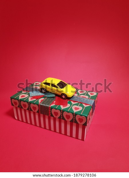 delivery of gifts and\
congratulations by couriers for Valentine\'s Day, yellow car on a\
red background, concept of a taxi and delivery of goods during\
quarantine