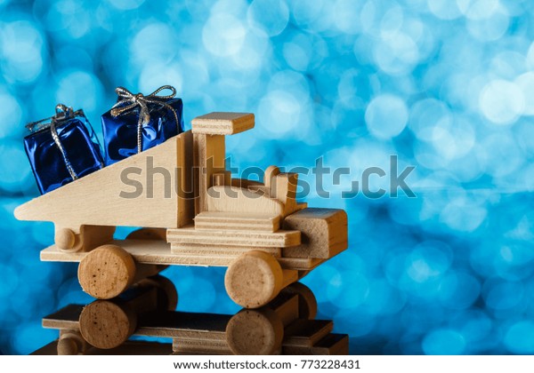 Delivery of gifts. Toy truck drives a\
little gift. Holiday card. A place for\
congratulations.