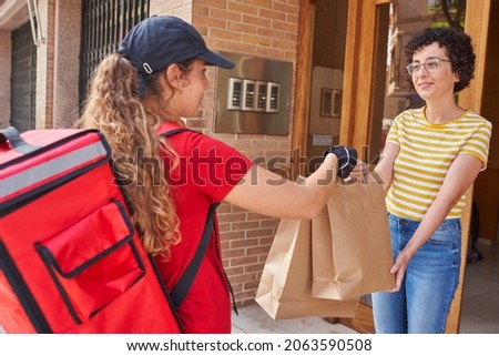 A delivery girl delivers bags of food on the street