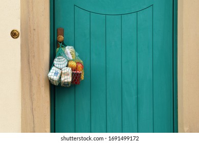delivery groceries during coronavirus infection Covid-19 quarantine. Shopping bag with Merchandise, goods, food hanging at the front door, neighborhood Assistance. helping of vulnerable people concept