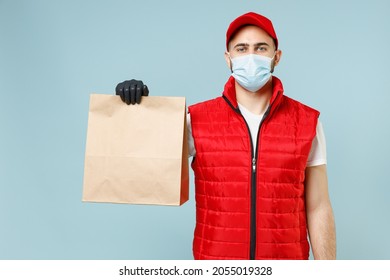 Delivery Guy Employee Man In Red Cap White Tshirt Vest Uniform Sterile Face Mask Gloves Work Courier Service On Lockdown Covid-19 Hold Blank Craft Paper Takeaway Bag Isolated On Pastel Blue Background