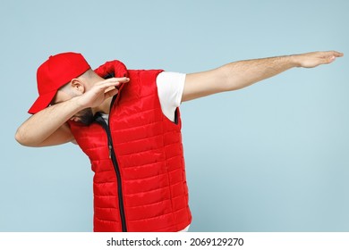 Delivery Guy Employee Man In Red Cap White T-shirt Uniform Workwear Work As Dealer Courier Doing Dab Hip Hop Dance Hands Move Gesture Isolated On Pastel Blue Color Background Studio. Service Concept