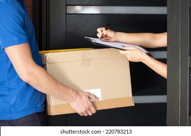 Delivery Guy Holding Package While Woman Is Signing Documents