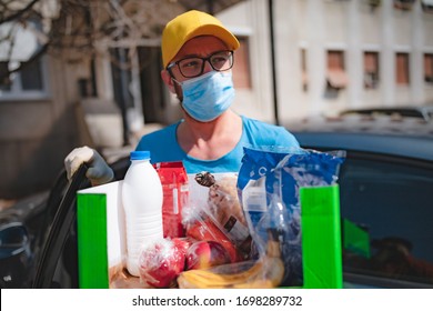 Delivery guy with protective mask and gloves delovering groceries during lockdown and pandemic.