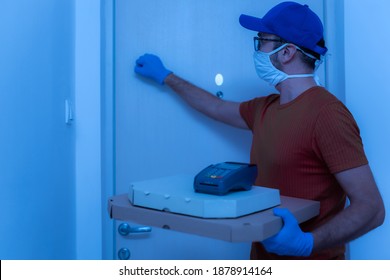 Delivery Guy With Protective Mask Holding Pizza Box At The Door.