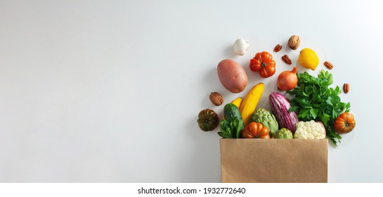 Delivery healthy food background. Healthy vegan vegetarian food in paper bag vegetables and fruits on white, copy space, banner. Shopping food supermarket and clean vegan eating concept