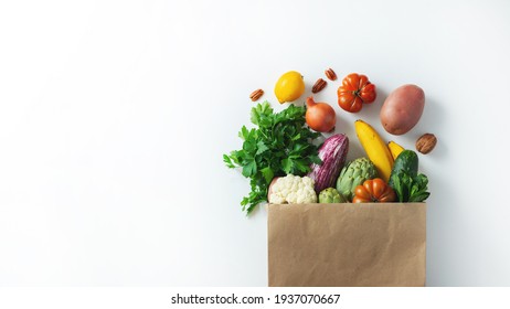 Delivery healthy food background. Healthy vegan vegetarian food in paper bag vegetables and fruits on white, copy space, banner. Shopping food supermarket and clean vegan eating concept. - Shutterstock ID 1937070667