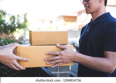 Delivery mail man giving parcel box to recipient, Young owner accepting of cardboard boxes package from post shipment, Home courier and delivery service mind concept. - Shutterstock ID 1304814736