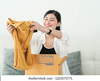 Delivery, Mail And People Concept - Smiling Asian Woman Opening Cardboard Box At Home.