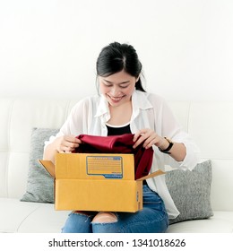 Delivery, Mail And People Concept - Smiling Asian Woman Opening Cardboard Box At Home.