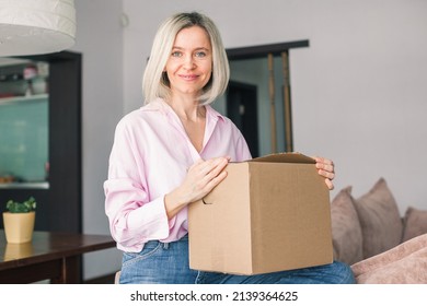 Delivery, Mail And People Concept - Smiling Middle Aged Woman Opening Cardboard Box At Home
