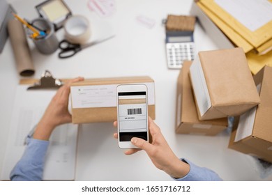 Delivery, Mail Service, People And Shipment Concept - Close Up Of Woman's Hads With Smartphone Scanning Barcode On Parcel Box At Post Office