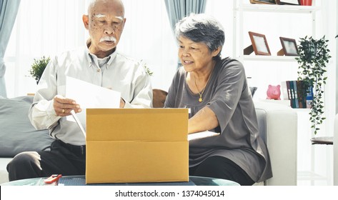 Delivery, Mail, Shipping And People Concept - Senior Man And Woman Opening Parcel Box At Home, 