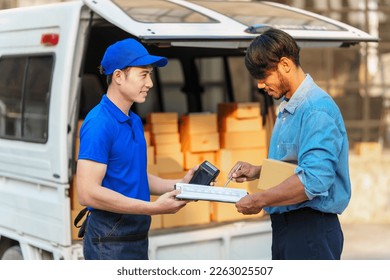 Delivery man asia people checking portable delivery device with parcel box to customer home address. give delivery box to customer and sign a signature of receiver people - Powered by Shutterstock