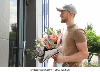 Delivery Man With Beautiful Flower Bouquet Near Front Door