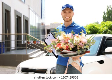 Delivery man with beautiful flower bouquet near car outdoors - Powered by Shutterstock