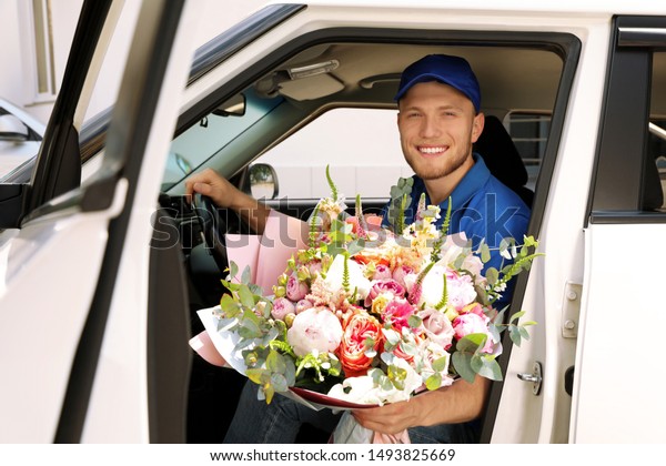 Delivery\
man with beautiful flower bouquet sitting in\
car