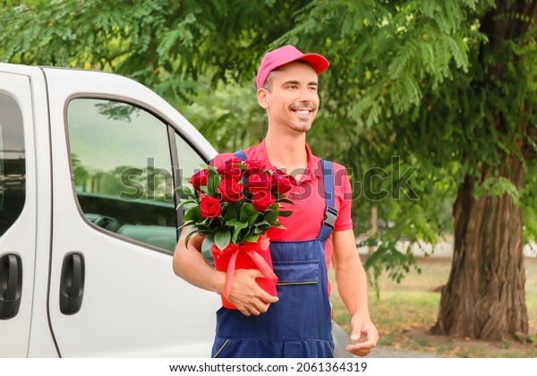 Delivery man\
with beautiful flowers near car\
outdoors