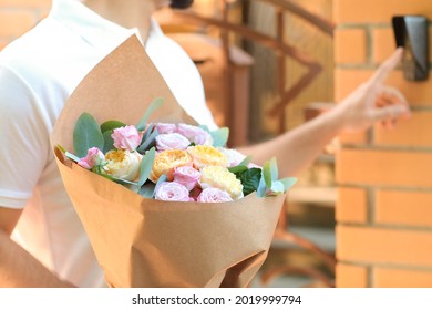 Delivery Man With Bouquet Of Beautiful Flowers Ringing Door Bell