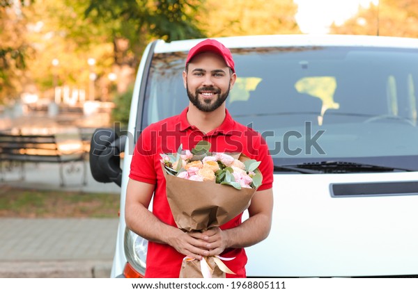 Delivery man with bouquet of beautiful flowers\
near car outdoors