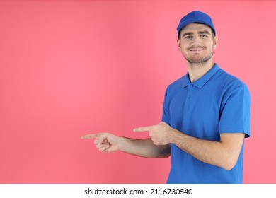 Delivery man in cap and t-shirt on pink background