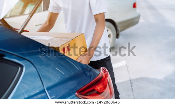 Delivery man carrying cardboard box for sending\
deliver to customer by transportation system hatchback car,\
Business of male transport sell part or product service parcel for\
convenience of\
customer