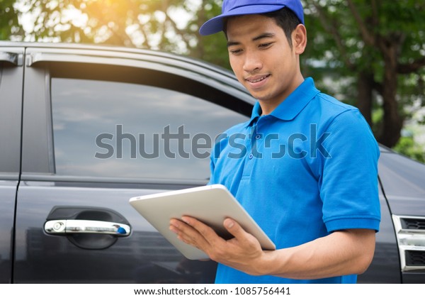 Delivery man checking\
document list on clipboard outdoor and Cardboard Boxes, Package\
delivery concept