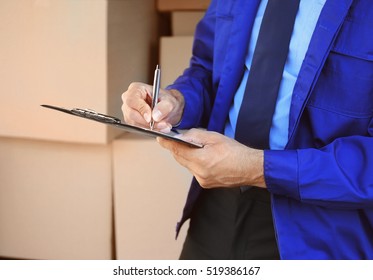 Delivery Man Checking List On Clipboard