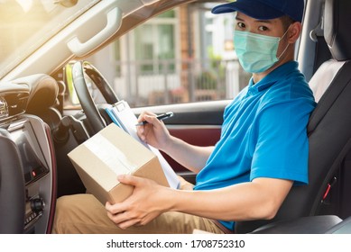 The delivery man is checking the parcel to be delivered on the car. Delivery man wearing a surgical mask. Delivery service concept. - Powered by Shutterstock