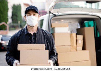 Delivery Man Courier With Face Mask Delivering Parcel Boxes In Town.