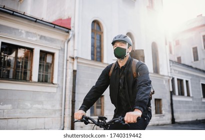 Delivery man courier with face mask and bicycle cycling in town. - Powered by Shutterstock