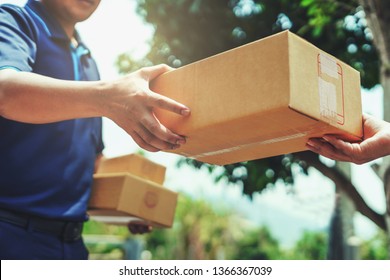Delivery man delivering holding parcel box to customer - Shutterstock ID 1366367039