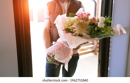 The Delivery Man Delivers A Bouquet Of Beautiful Flowers To Home