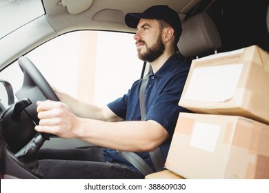 Delivery Man Driving His Van With Packages On The Front Seat