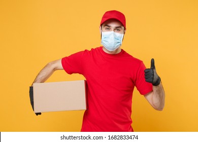 Delivery man employee in red cap blank t-shirt uniform face mask gloves hold empty cardboard box isolated on yellow background studio Service quarantine pandemic coronavirus virus 2019-ncov concept