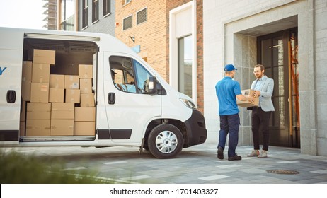 Delivery Man Gives Postal Package to a Business Customer, Who Signs Electronic Signature POD Device. In Stylish Modern Urban Office Area Courier Delivers Cardboard Box Parcel to a Man.