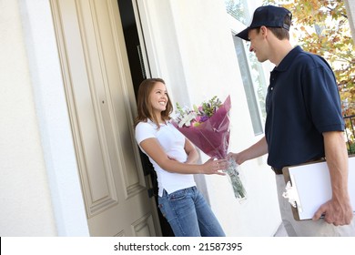 A  Delivery Man Giving Flowers To Pretty Woman At Home